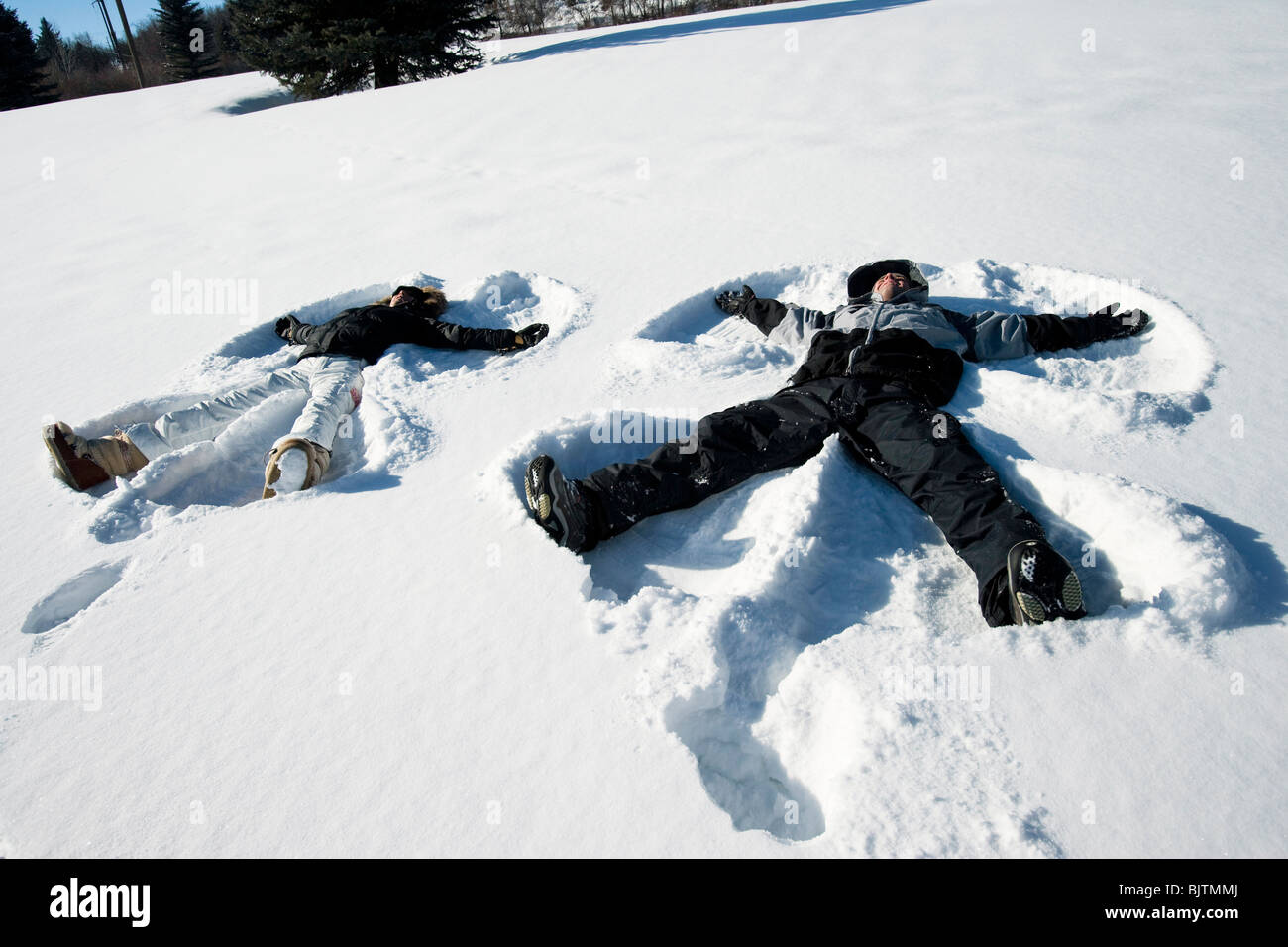 Giovane rendendo gli angeli di neve Foto Stock