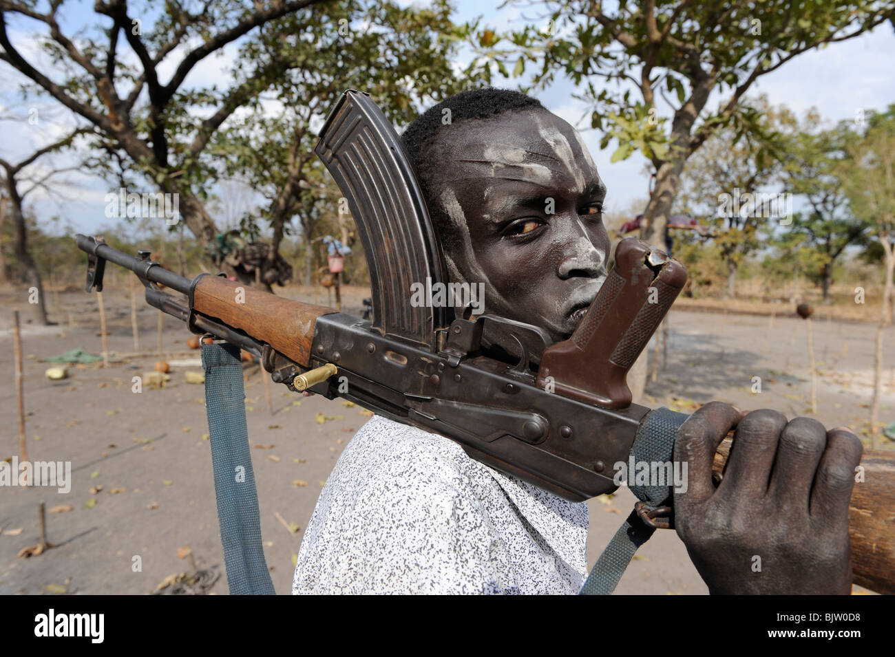 Del sud-Sudan, Cuibet vicino a Rumbek, pastore con la cenere cosparsa faccia in posa con Kalashnikov mitragliatrice AK-47 nel bestiame camp Foto Stock