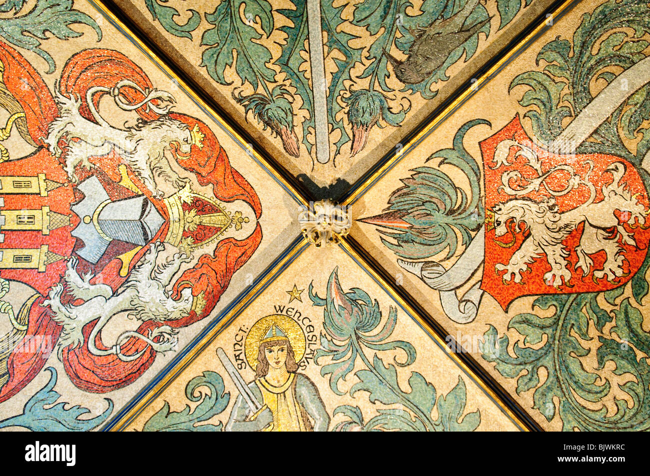 Vecchio Municipio soffitto a mosaico San Venceslao stemmi Praga Repubblica Ceca // PRAGA, Repubblica Ceca - Una vista dettagliata del soffitto a mosaico in Art Nouveau nella sala d'ingresso del Municipio Vecchio, con una raffigurazione di San Venceslao e gli stemmi di Praga e Boemia. I mosaici furono creati tra il 1937 e il 1939 dal mosaicista Stanislav Ulman, sulla base di precedenti disegni del famoso artista ceco Mikoláš Aleš. Questo soffitto ornato decora il vestibolo del Municipio della città Vecchia (Staroměstská radnice) sulla Piazza della città Vecchia. L'opera celebra le figure chiave e i simboli del ceco Foto Stock
