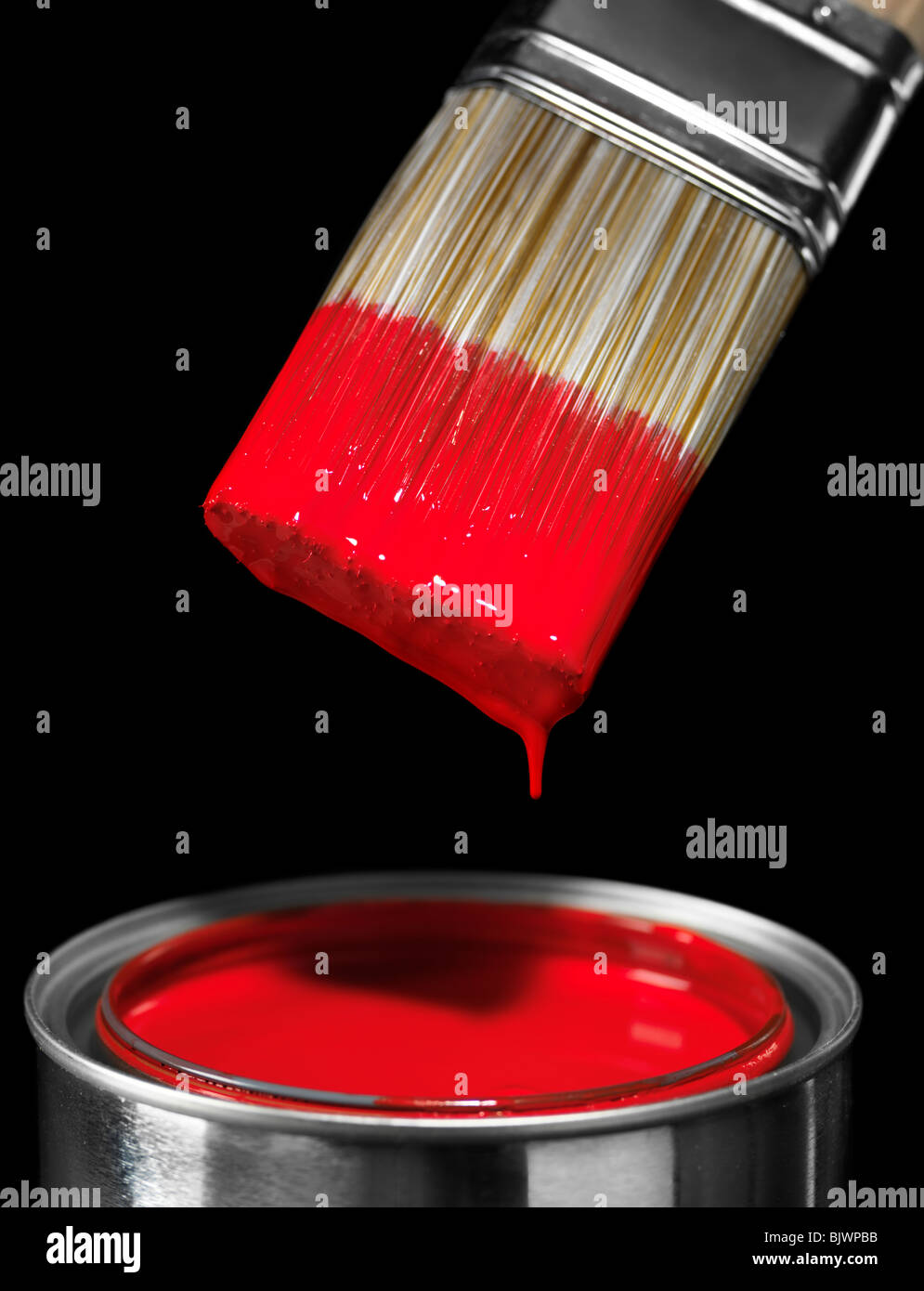 Pennello immerso in vernice rossa isolato su sfondo nero Foto Stock