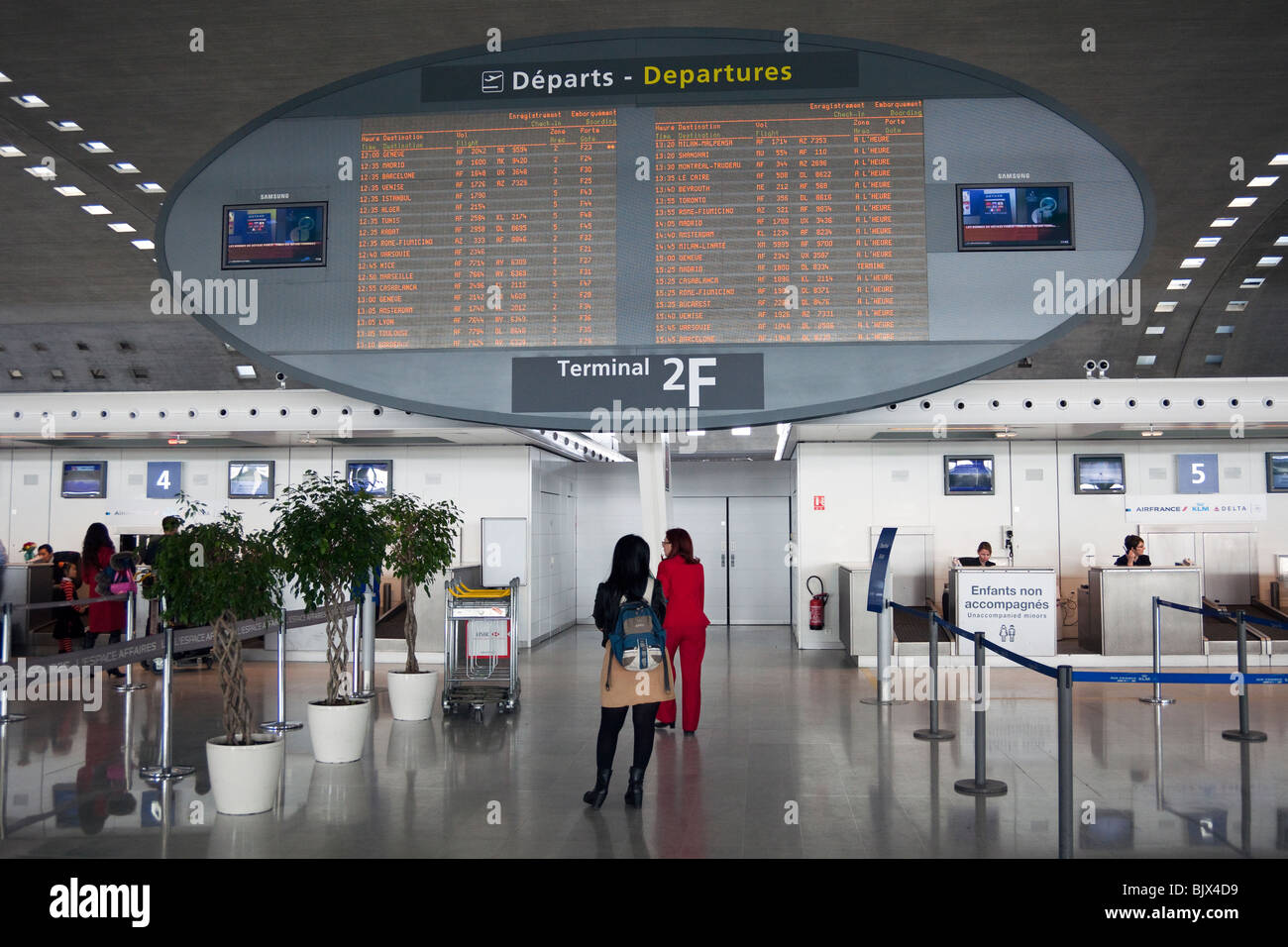 Guardando ai passeggeri in partenza scheda annunci, terminale 2, aeroporto Charles de Gaulle di Roissy, Francia Foto Stock