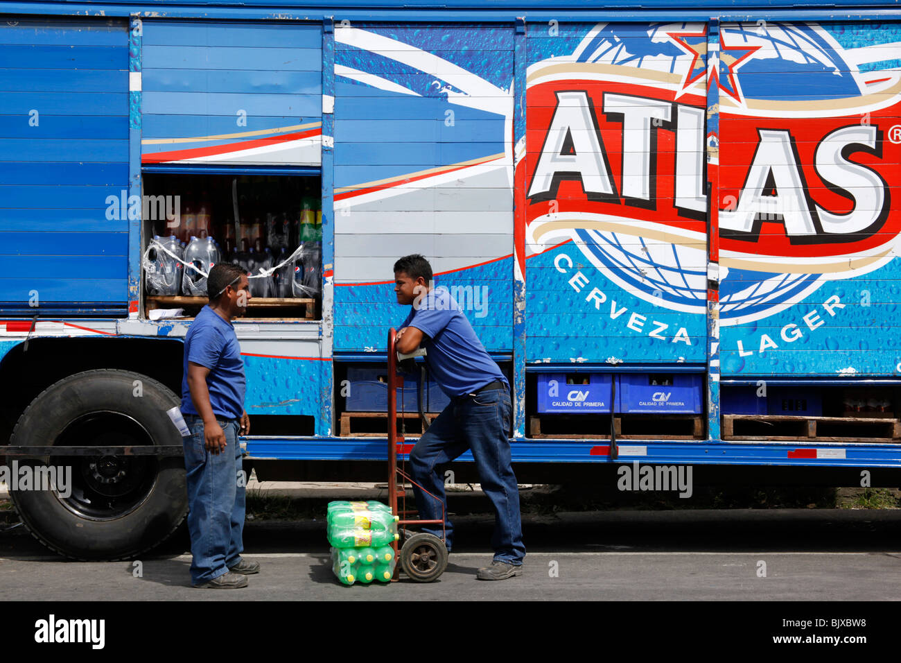 Due uomini che chiacchierano mentre scaricavano bevande analcoliche dal camion di consegna della birra Atlas a Market, Penonome, provincia di Cocle, Panama Foto Stock