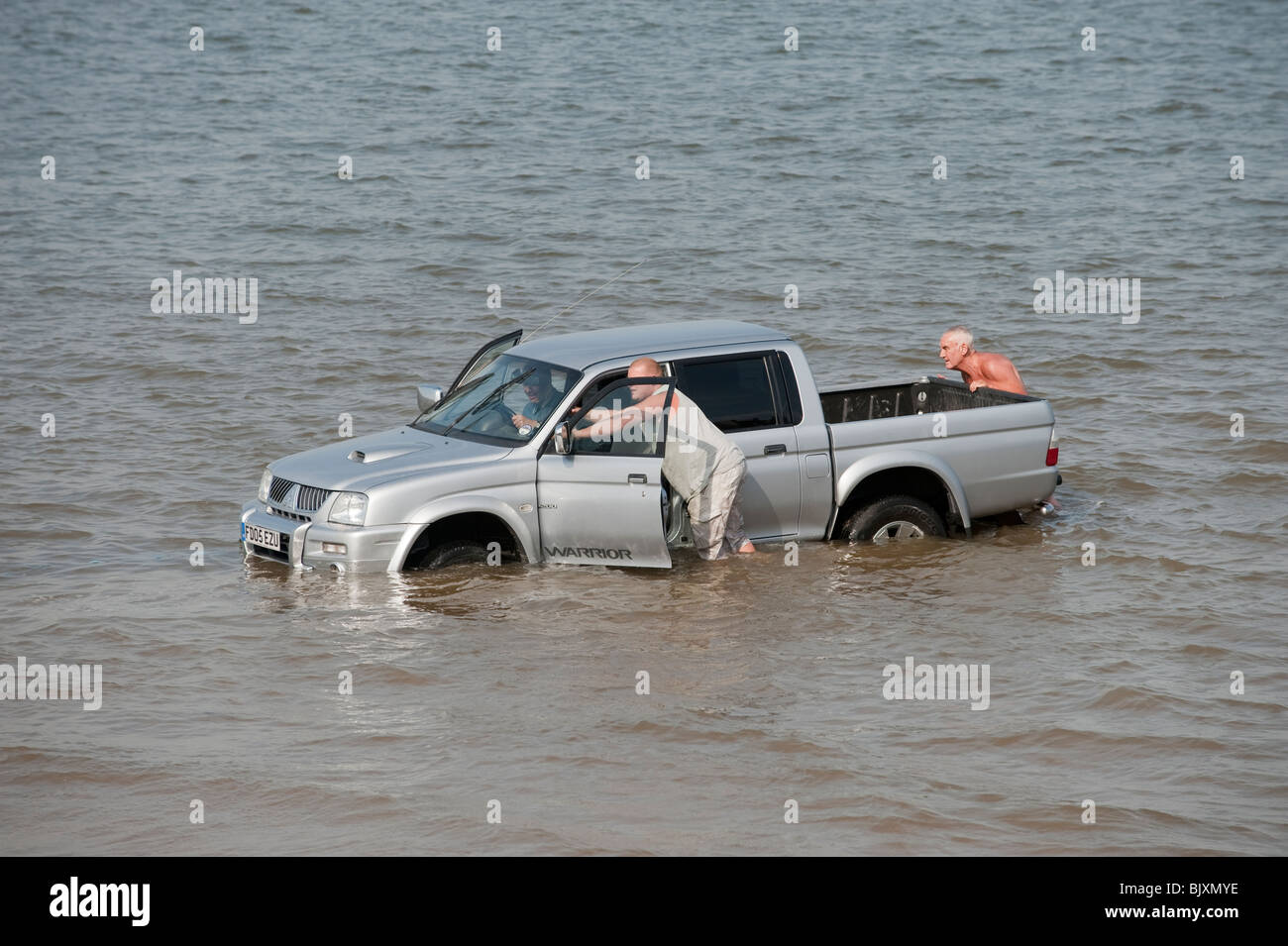 Auto / carrello / SUV bloccato in morbida sabbia sulla spiaggia con marea Foto Stock