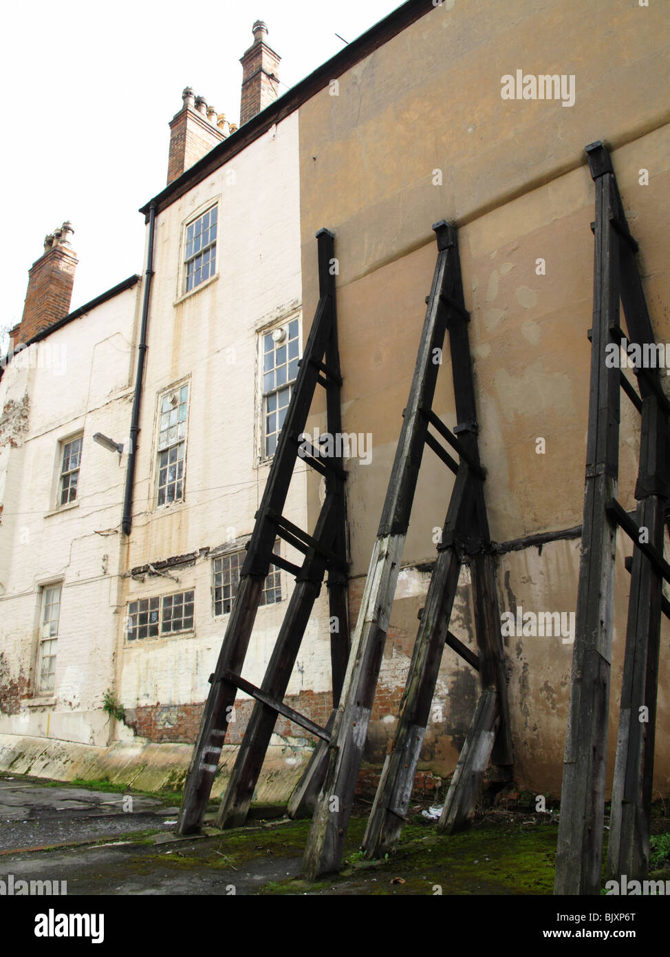 Supporti strutturali su un vecchio edificio in una città del Regno Unito. Foto Stock