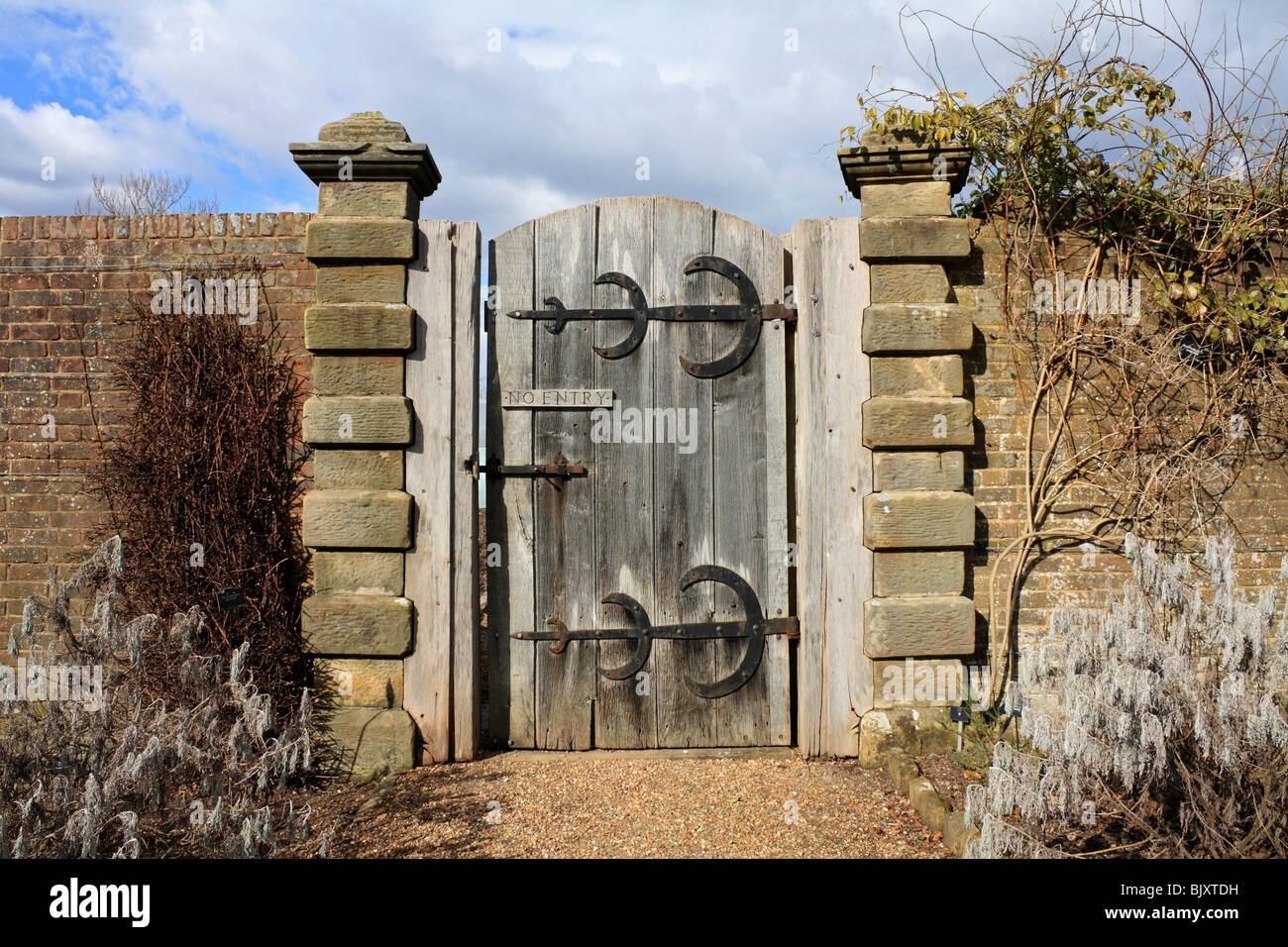 Robusti in legno antico cancello del giardino con nessun segno di entrata e grandi cerniere in ottone, Sussex England Regno Unito Foto Stock