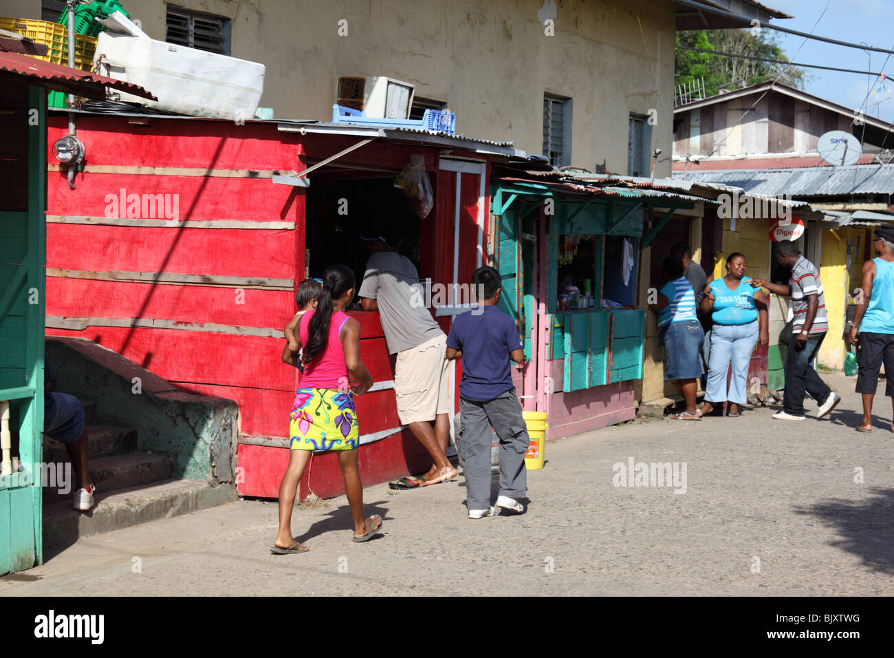 Embera ragazza (nel mantello giallo) e le bancarelle del mercato nella strada principale di La Palma , Darien , Panama Foto Stock