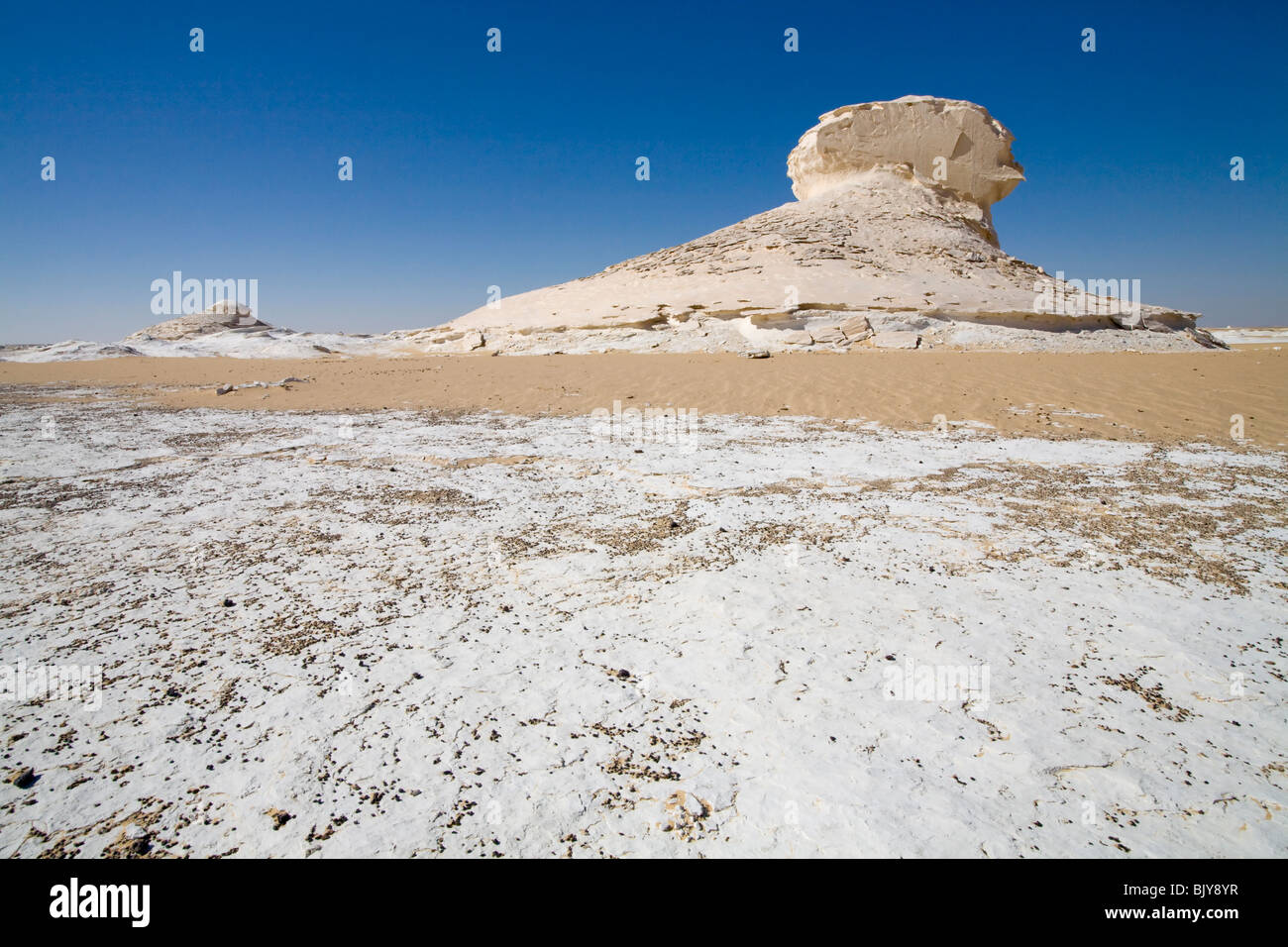 Inselburgs con circostante sabbia ondulata, in condizioni di luce solare intensa,Bianco Deserto, Farafra, Egitto, Nord Africa Foto Stock