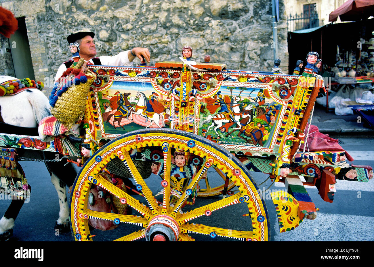 Monreale, sicilia, Italia. Dipinto a mano cavallo decorata carrello con autista fuori la Cattedrale di Monreale utilizzato come taxi turistici Foto Stock