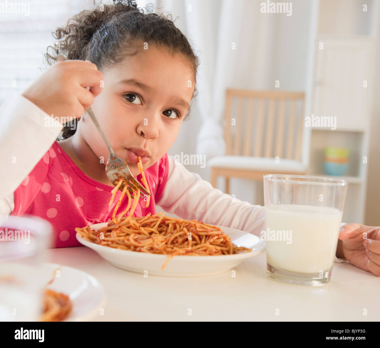 Ragazza ispanica mangiare spaghetti Foto Stock
