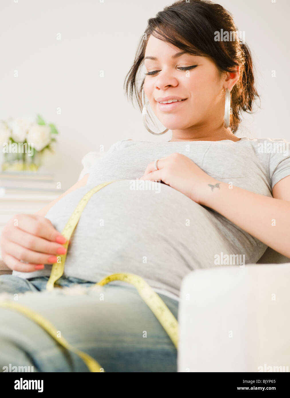 Incinta donna ispanica stomaco di misurazione Foto Stock