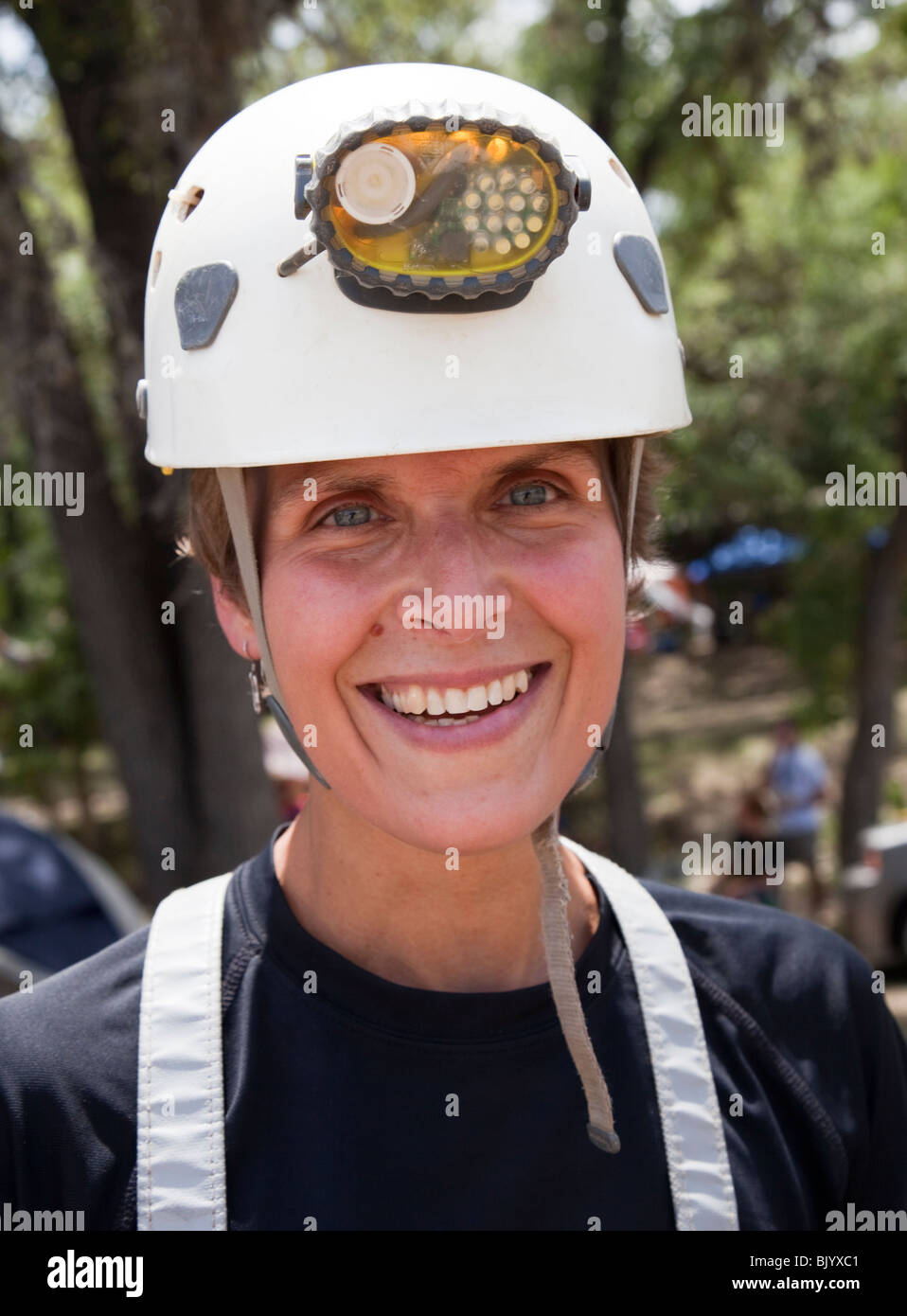 Donna speleologo con casco e luce sorridente Texas USA Foto Stock