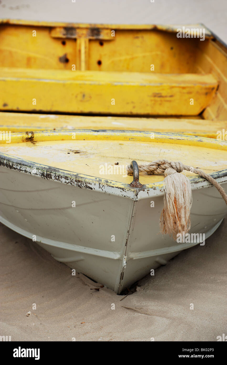 Un alluminio (alluminio) imbarcazione dipinte di giallo e sbiadimento poggia sulla sabbia della spiaggia dell'isola, Kangaroo Island, Sud Australia Foto Stock