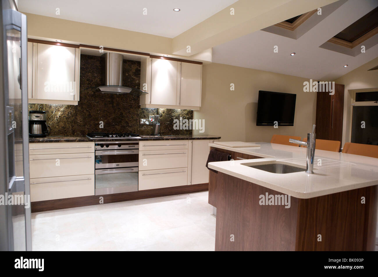 Luminosa e moderna cucina / soggiorno con cucina attrezzata e bancone di marmo alto e un isola di quarzo. Casa di famiglia e area soggiorno. Foto Stock