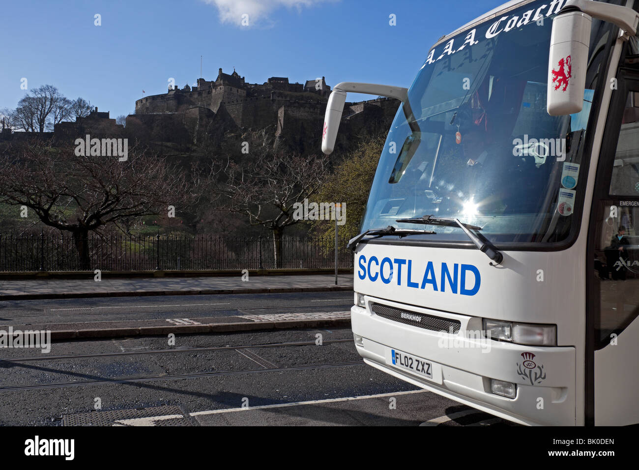 Viaggiare in autobus lungo Princes Street Edinburgh Castle in background, Scotland, Regno Unito, Europa coach Foto Stock