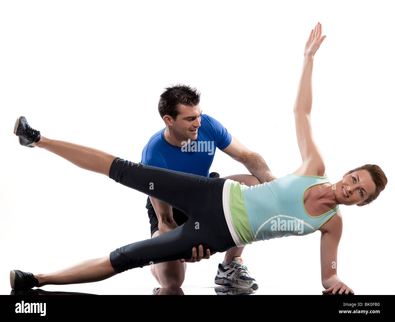 Un caucasian giovane uomo aerobico posizionamento trainer donna trainer postura in interni studio isolato su sfondo bianco Foto Stock