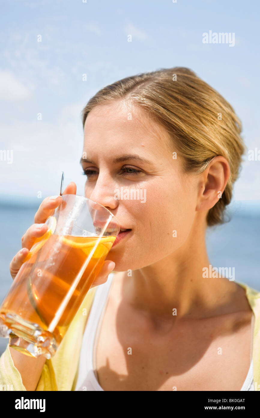 Donna di bere un tè freddo Foto Stock
