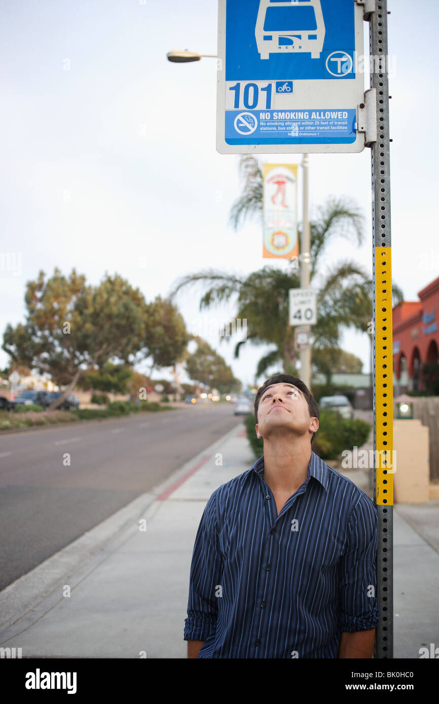 Razza mista uomo che guarda al bus stop Foto Stock