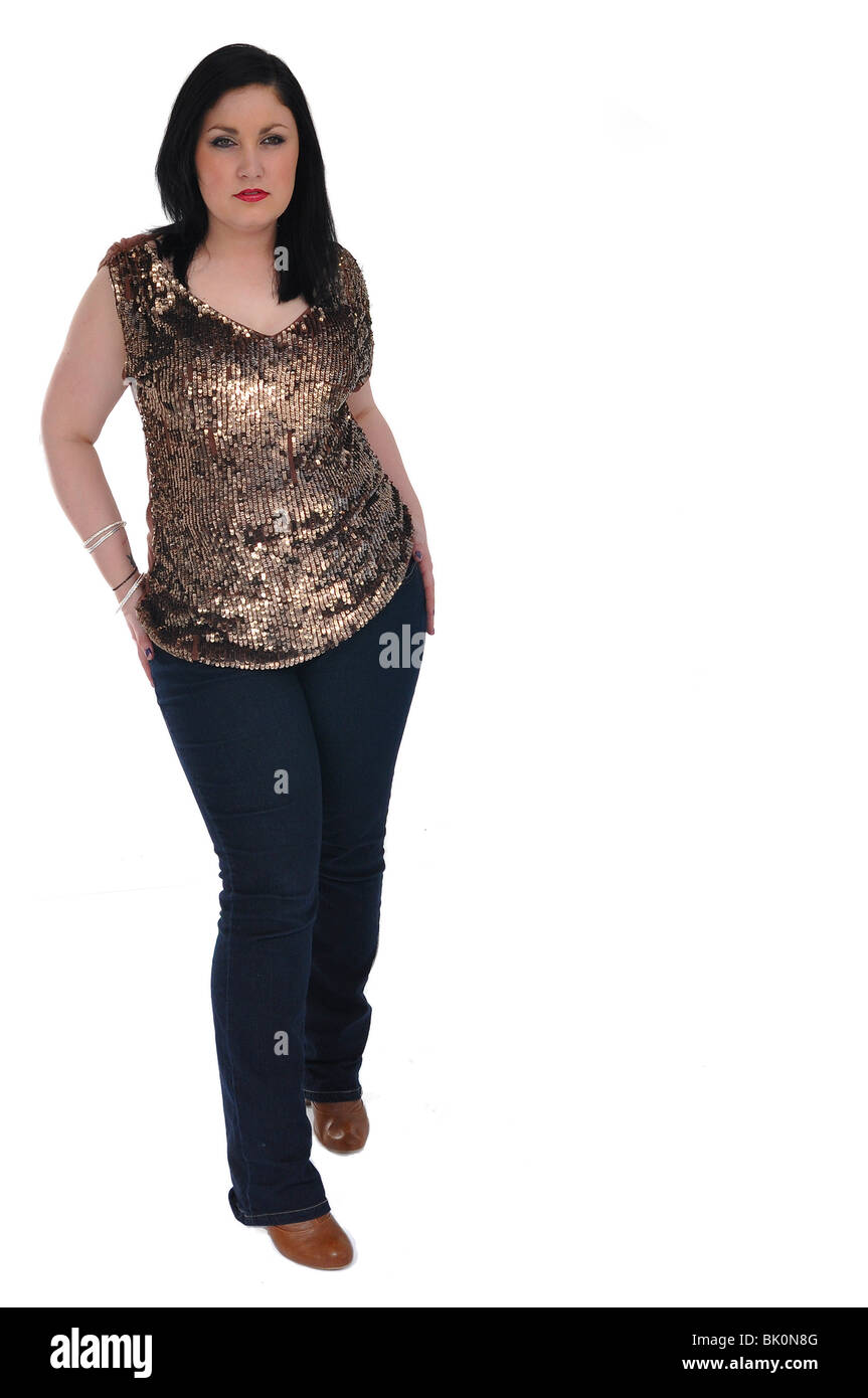 A piena lunghezza Ritratto di una giovane donna in oro sequined top e dark blue jeans Foto Stock