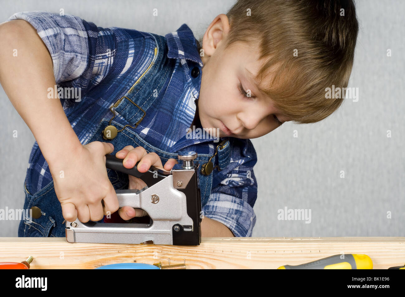 Carino kid come un lavoratore edile, giocando con gli strumenti Foto Stock