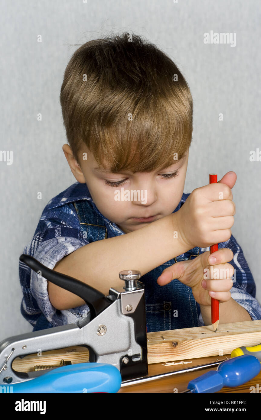 Carino kid come un lavoratore edile, giocando con gli strumenti Foto Stock