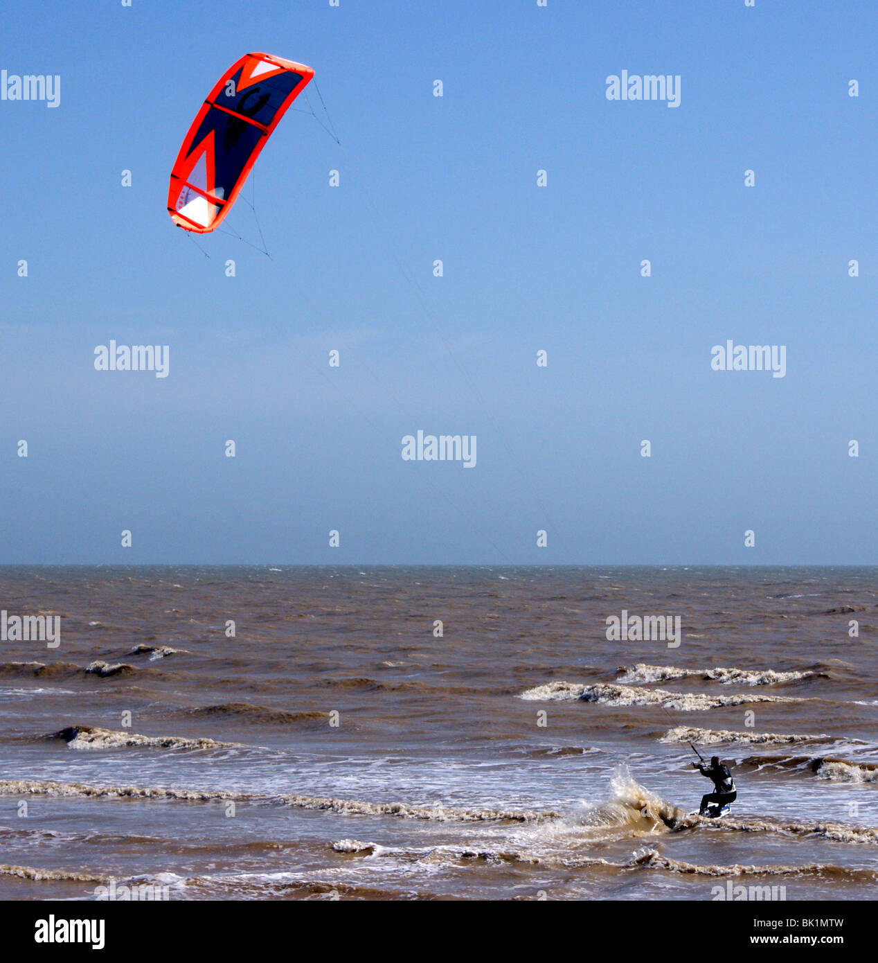 Kite Surfer usando un vivacemente colorato aquilone al potere lui lungo. Foto Stock