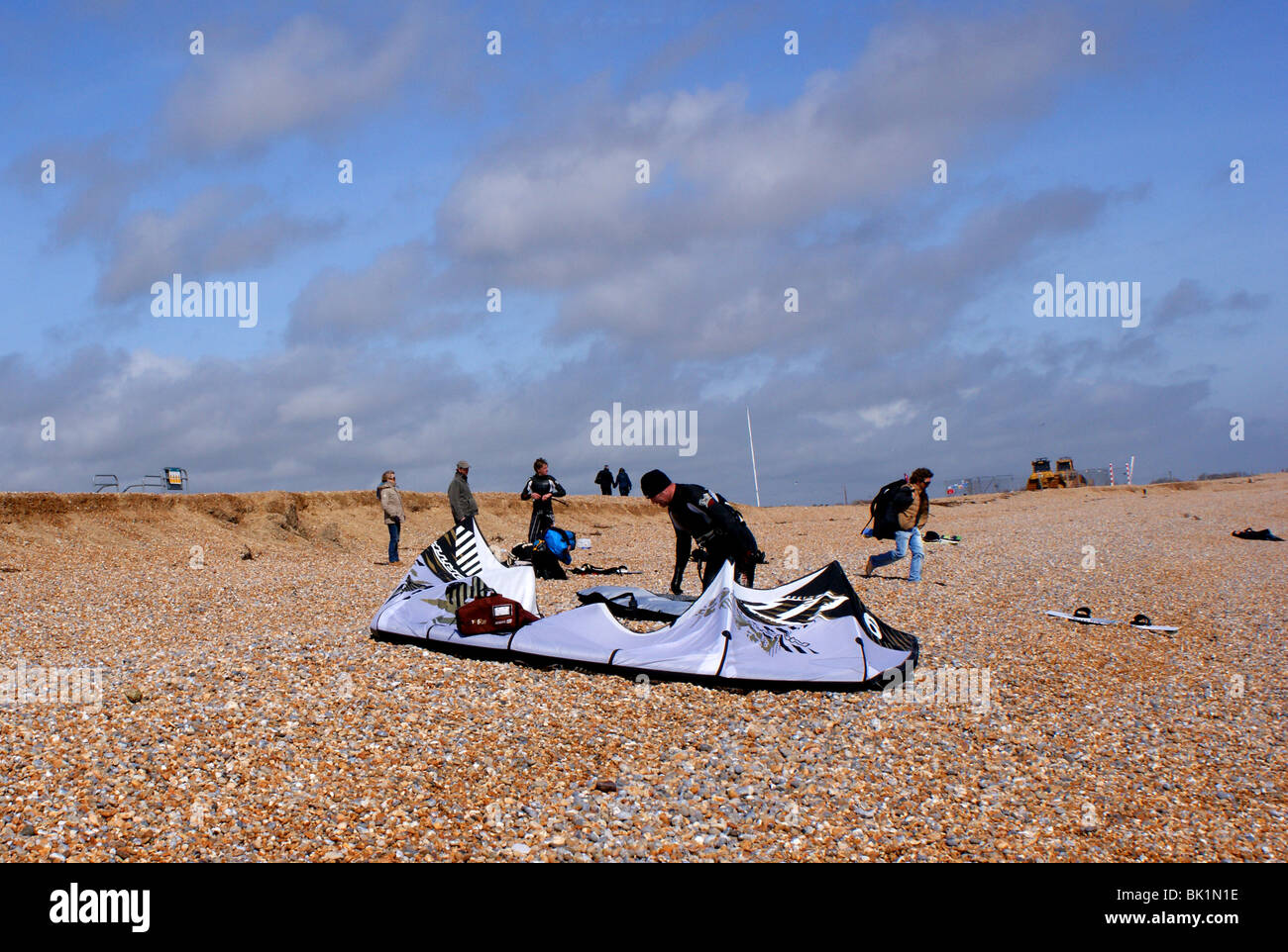 Un uomo prepara il suo Kite surf sulla spiaggia di Winchelsea in East Sussex Foto Stock