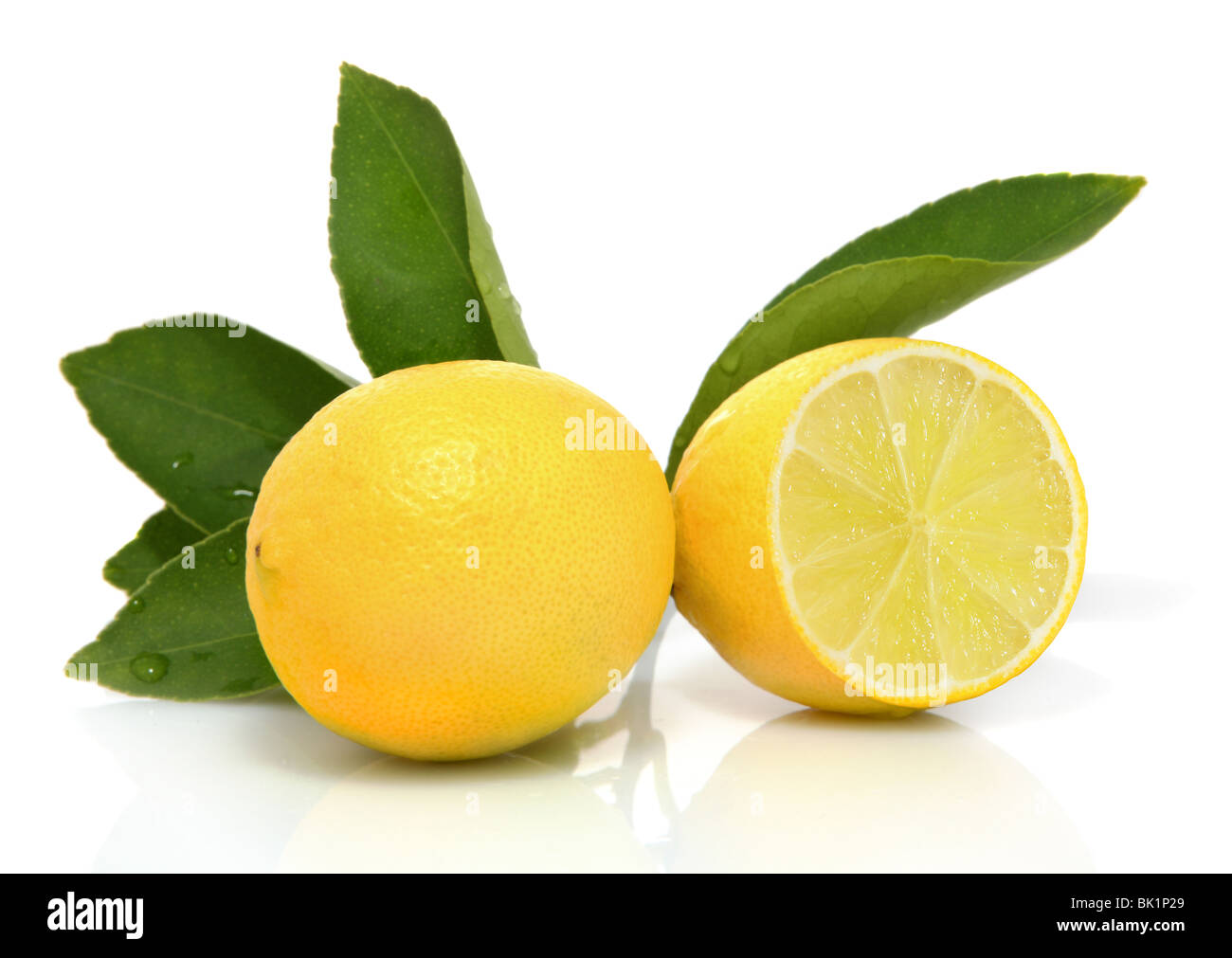 Intero e fette di limoni organico con foglie su sfondo bianco Foto Stock