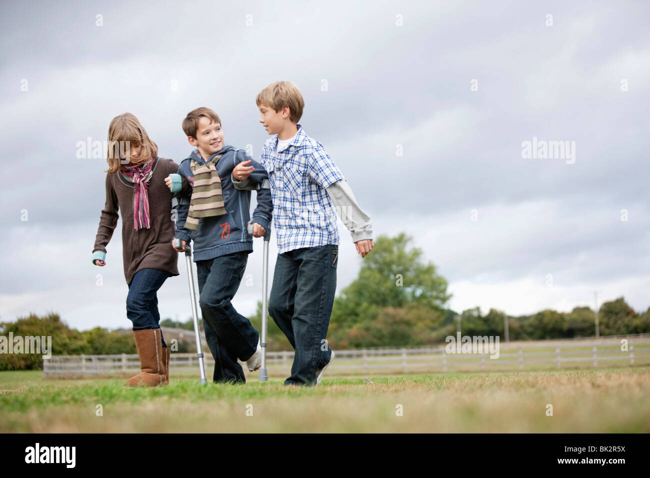 I bambini aiutano i boy su stampelle Foto stock - Alamy