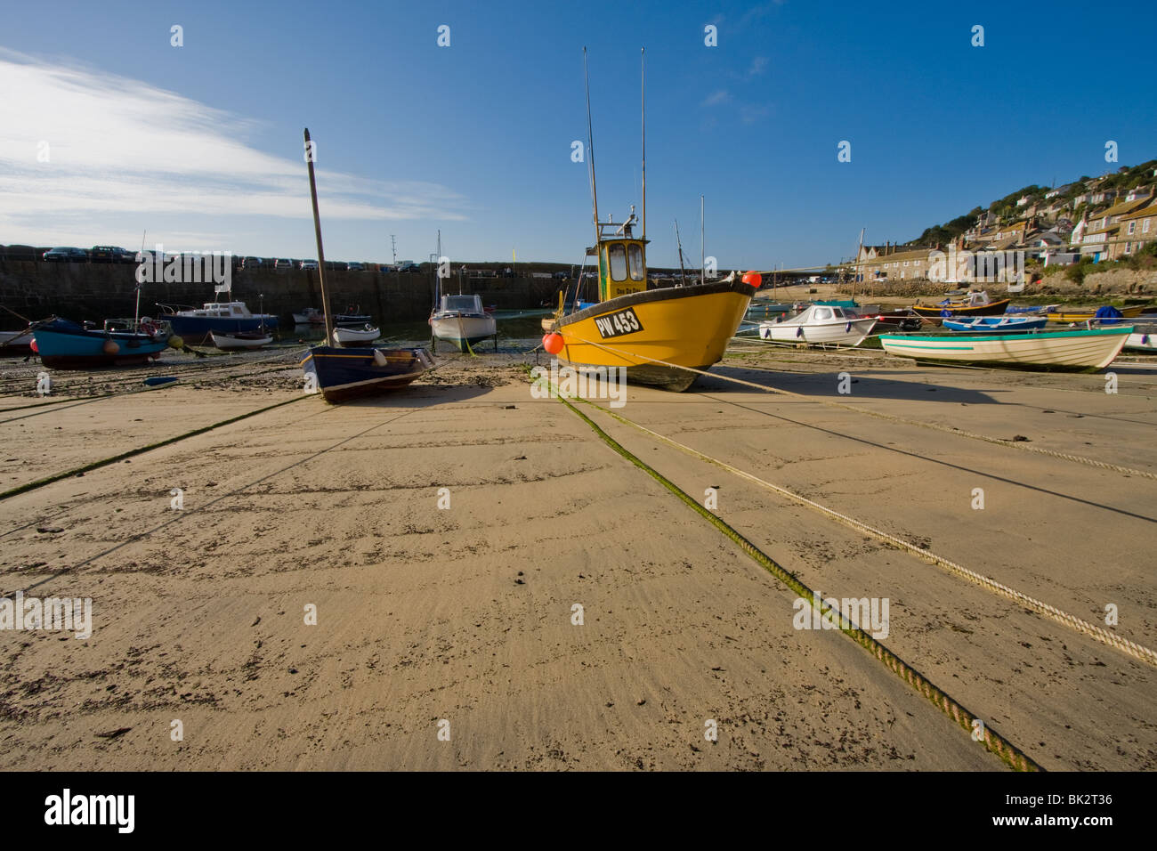 Barche a bassa marea in Mousehole Harbour, Cornwall, Regno Unito Foto Stock