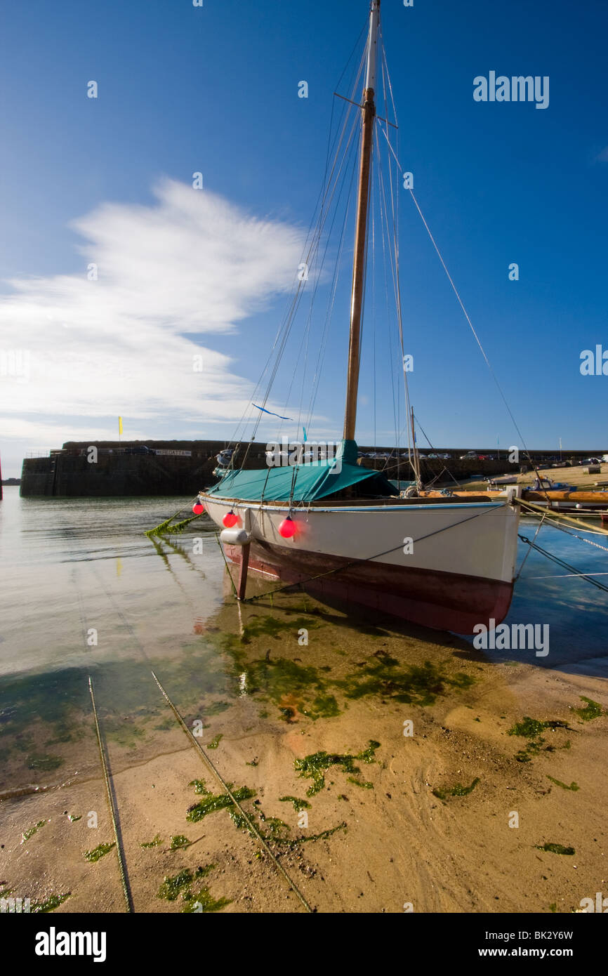 Barche a bassa marea in Mousehole Harbour, Cornwall, Regno Unito Foto Stock