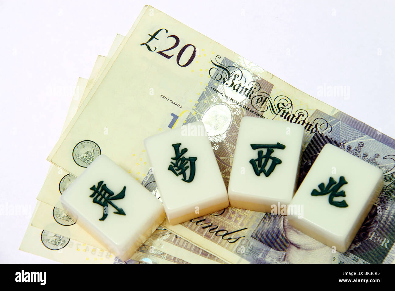 Cinese piastrelle mahjong insieme contro la valuta britannica che mostra migranti cinesi in Gran Bretagna. Foto Stock