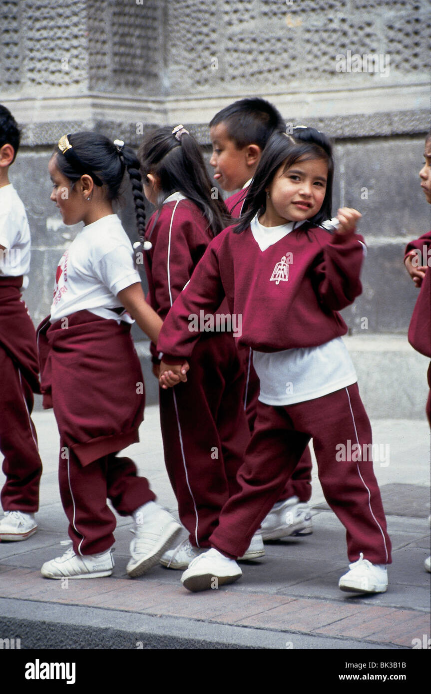 La scuola dei bambini in uniforme, tenendo le mani e piedi in linea, Ecuador Foto Stock