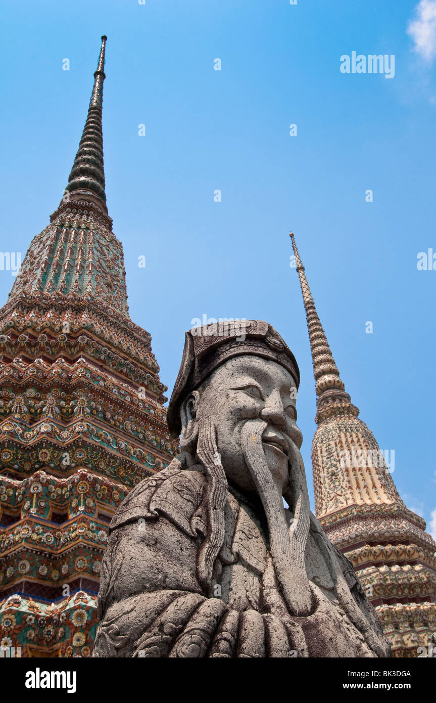 Stone Guard statua e chedi a Wat Pho, il Tempio del Buddha Reclinato, il più grande tempio buddista di Bangkok Foto Stock