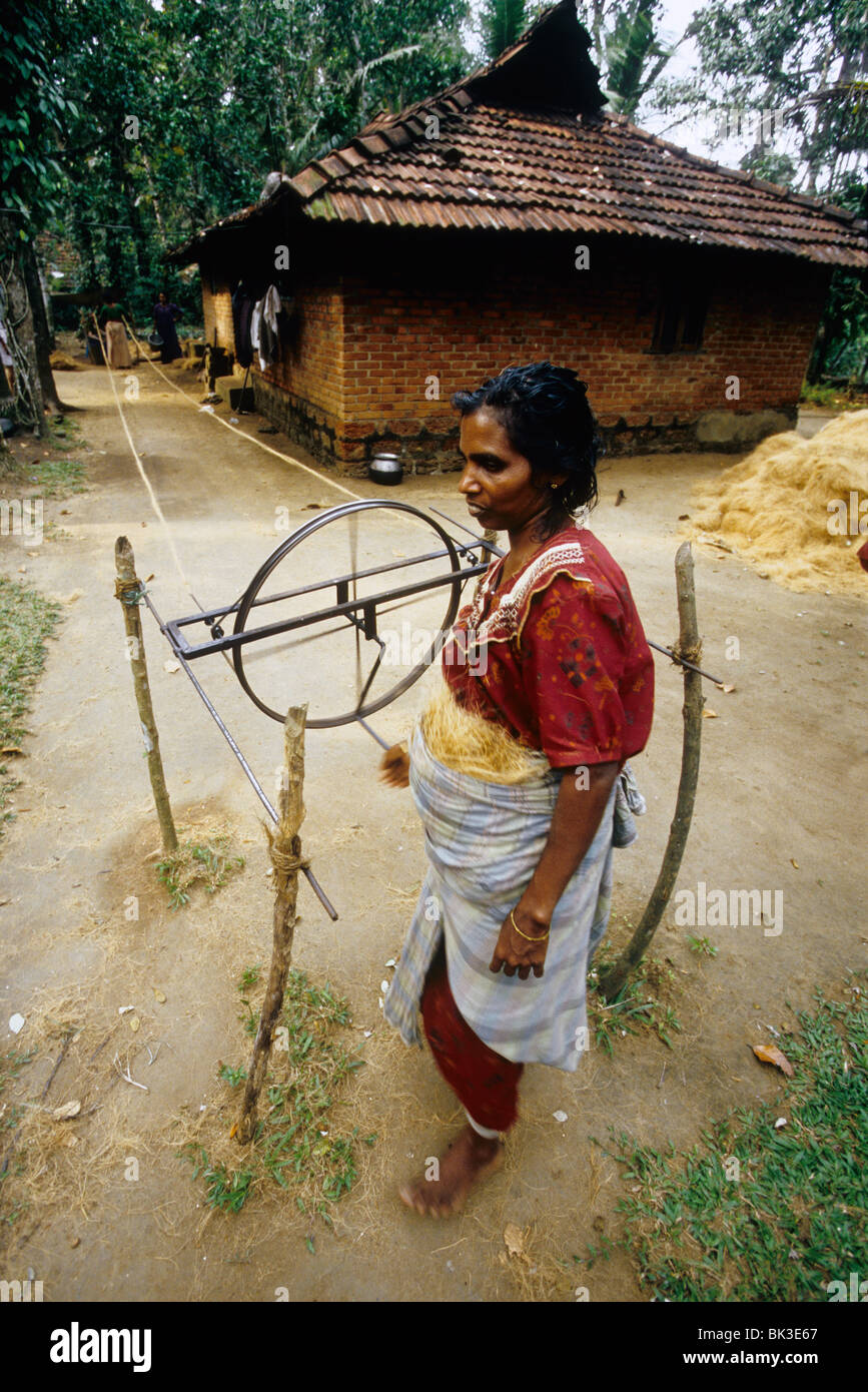 Donna che fa la corda con fibra di noce di cocco denominato "" di cocco in modo tradizionale in un villaggio backwaters Foto Stock