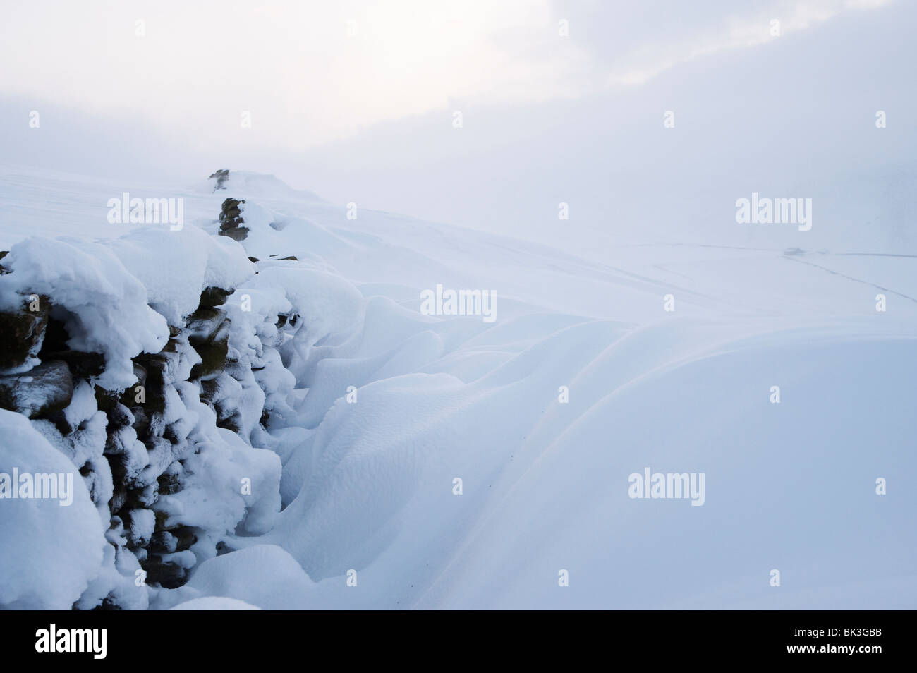 Modelli di neve formata da vento neve soffiata accanto a una parete di stalattite, Peak District, Derbyshire, Regno Unito Foto Stock