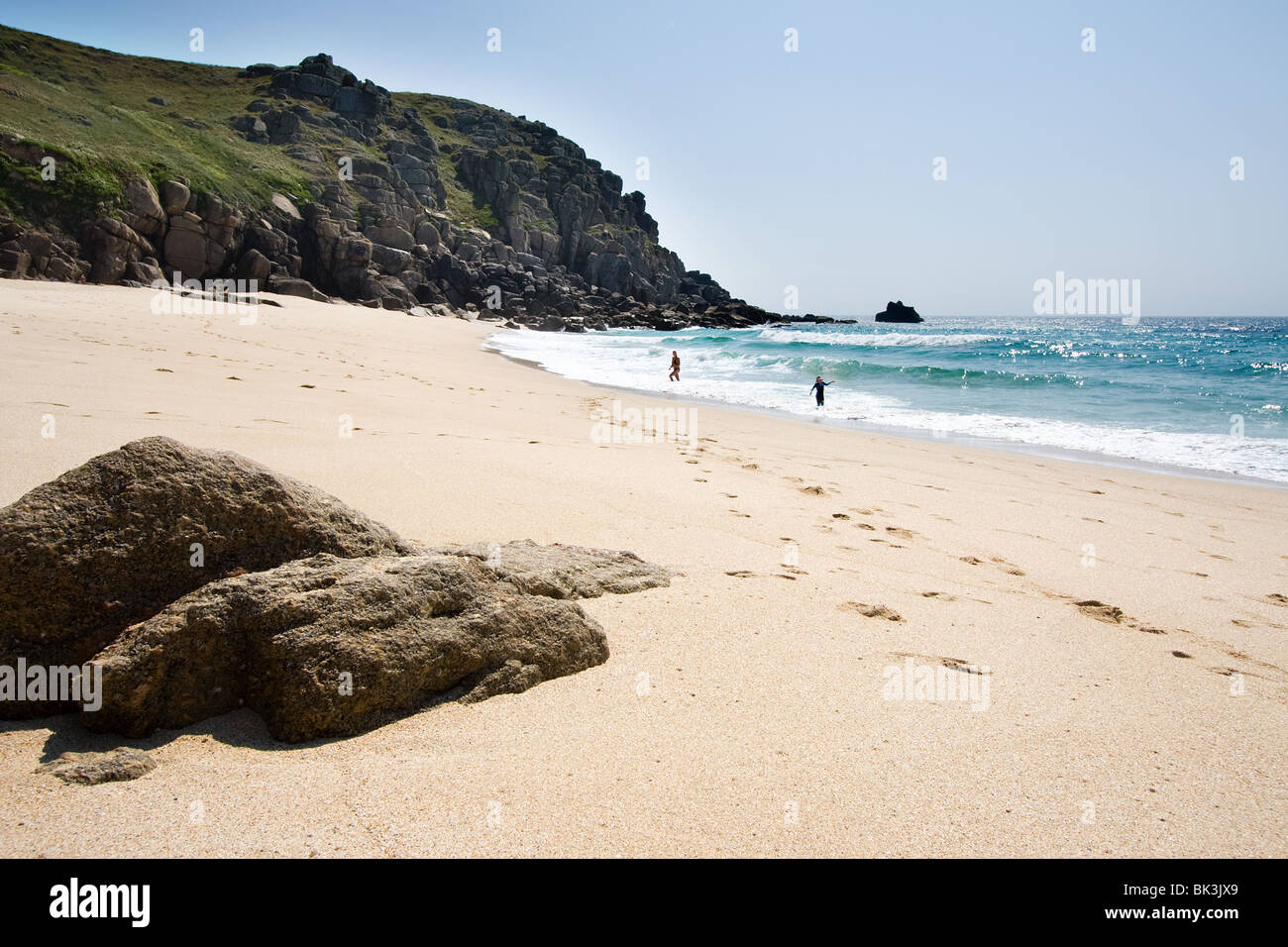 Due persone che giocano in mare su una spiaggia deserta, Cornwall, Regno Unito Foto Stock