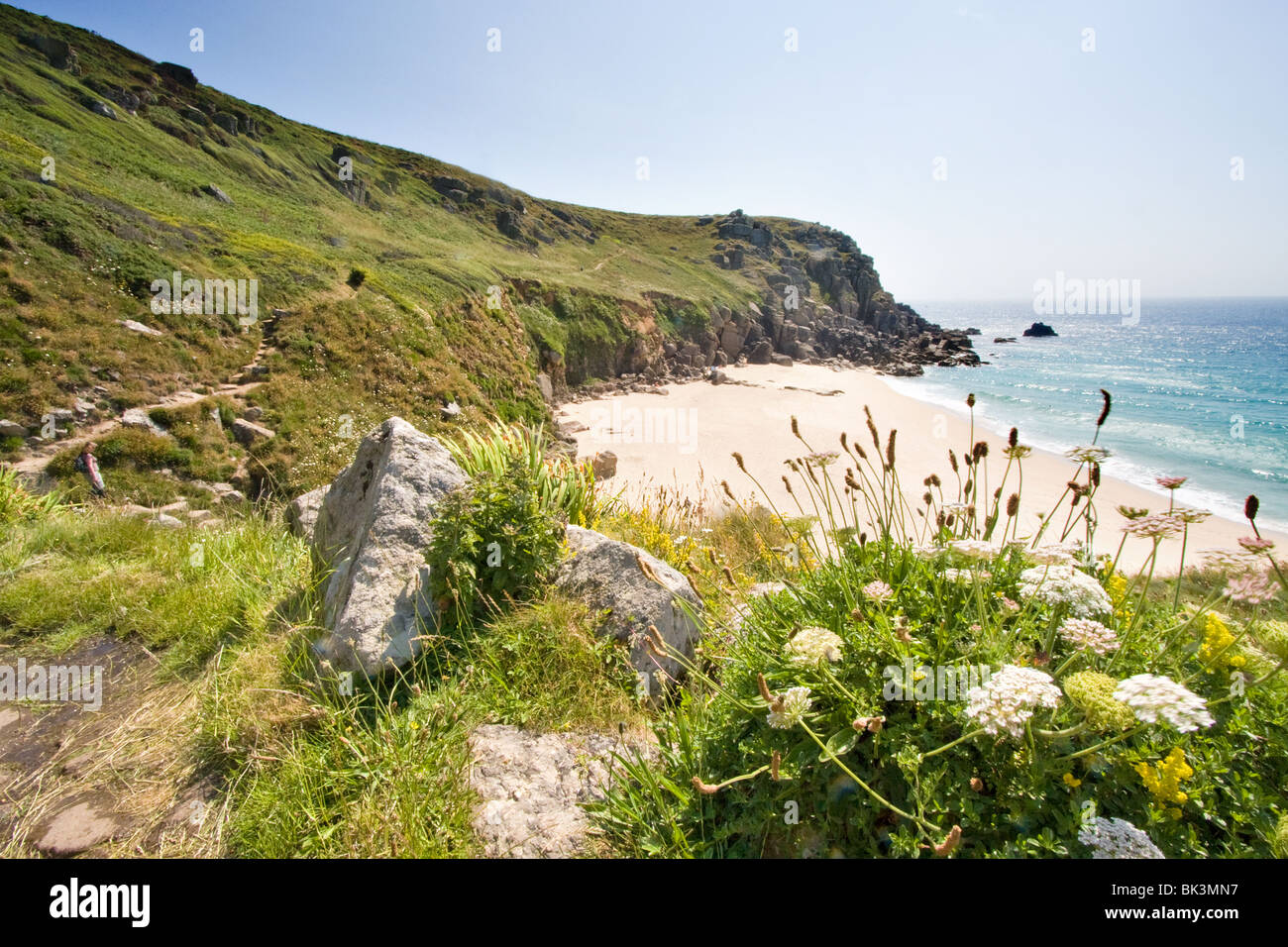 Guardando a una spiaggia deserta dal sentiero costiero, Cornwall, Regno Unito Foto Stock