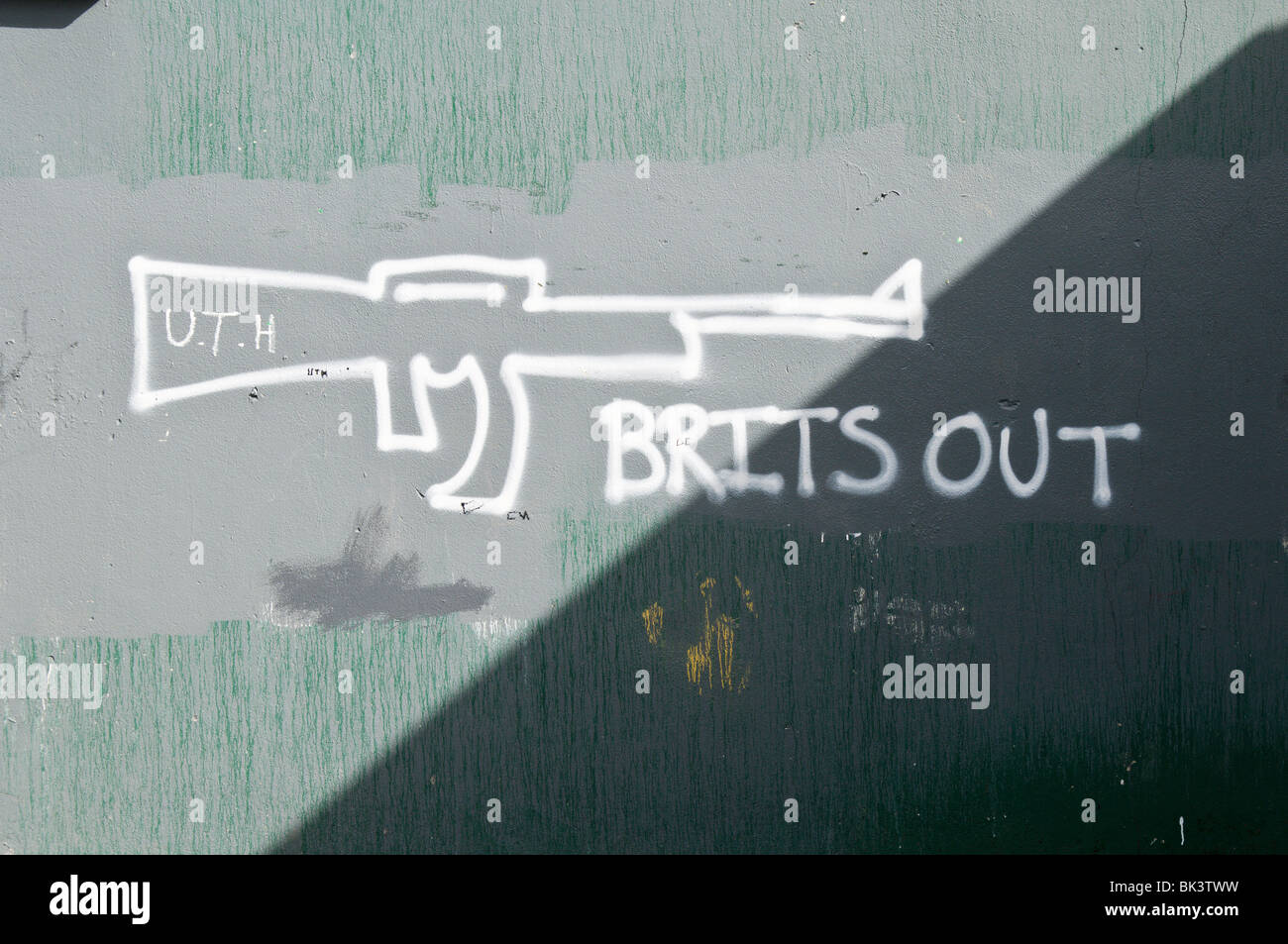 Grafitti su una parete, 'Brits Out' con un AK-47 gun Foto Stock