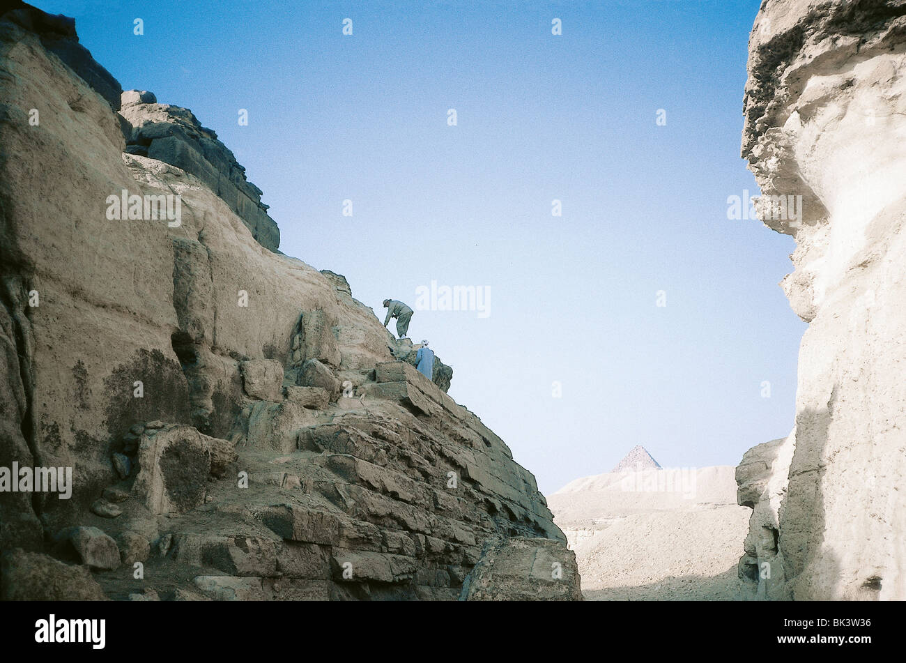 Guida turistica e locale che arrampica su una piramide, Egitto Foto Stock