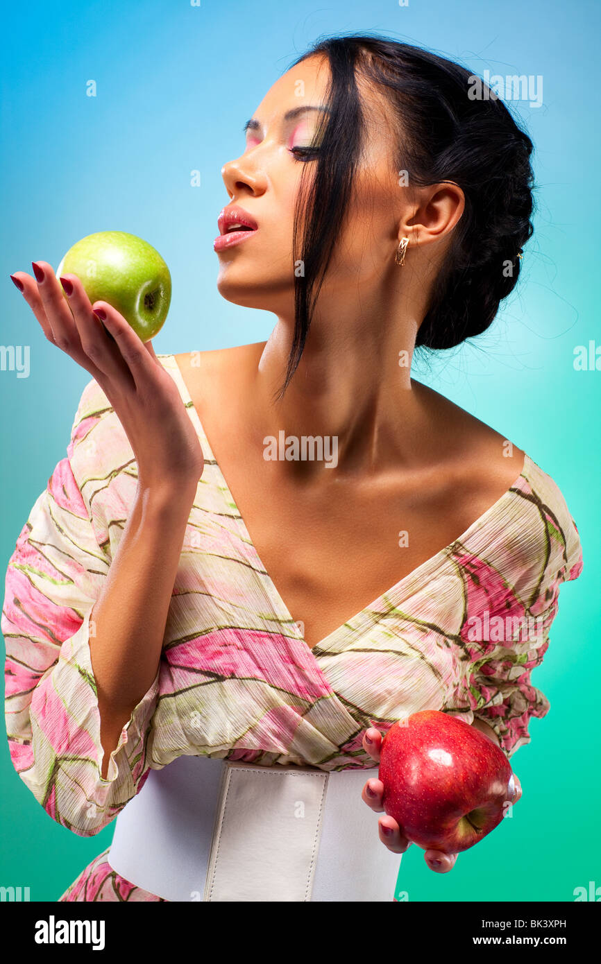 Giovane donna con due mele. Ricca di colori brillanti. Foto Stock