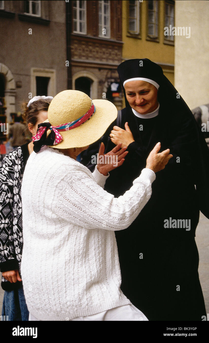 Una conversazione con una suora cattolica romana e una donna che indossa un cappello di paglia sulla strada a Varsavia, Polonia Foto Stock