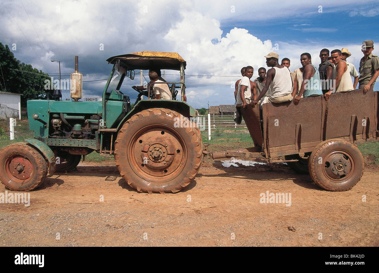 Un trattore tirando un carro caricato con i lavoratori agricoli, Cuba Foto Stock