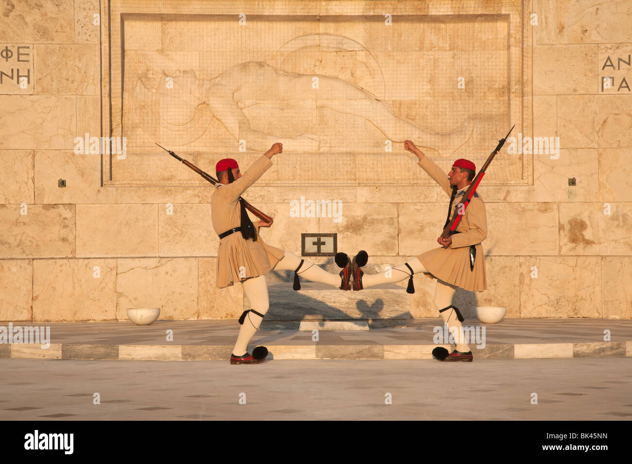 Guardia presidenziale di Evzones in marcia, Tomba del Milite Ignoto e scultura di hoplite morente al Parlamento greco di Atene Foto Stock