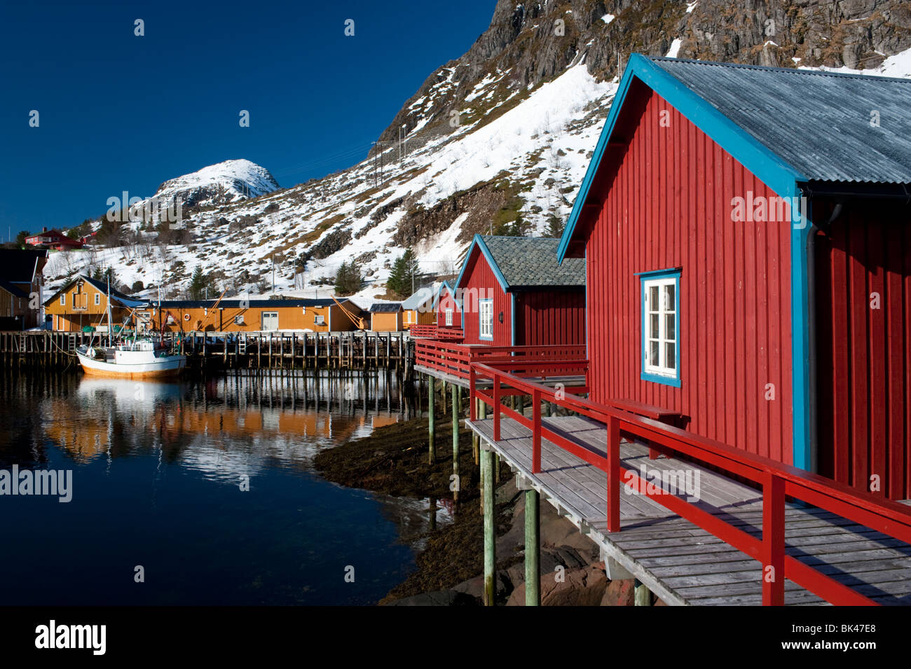 Tradizionale in legno rosso di pescatori di capanne Rorbu dal mare nel villaggio Tind nelle Isole Lofoten in Norvegia Foto Stock
