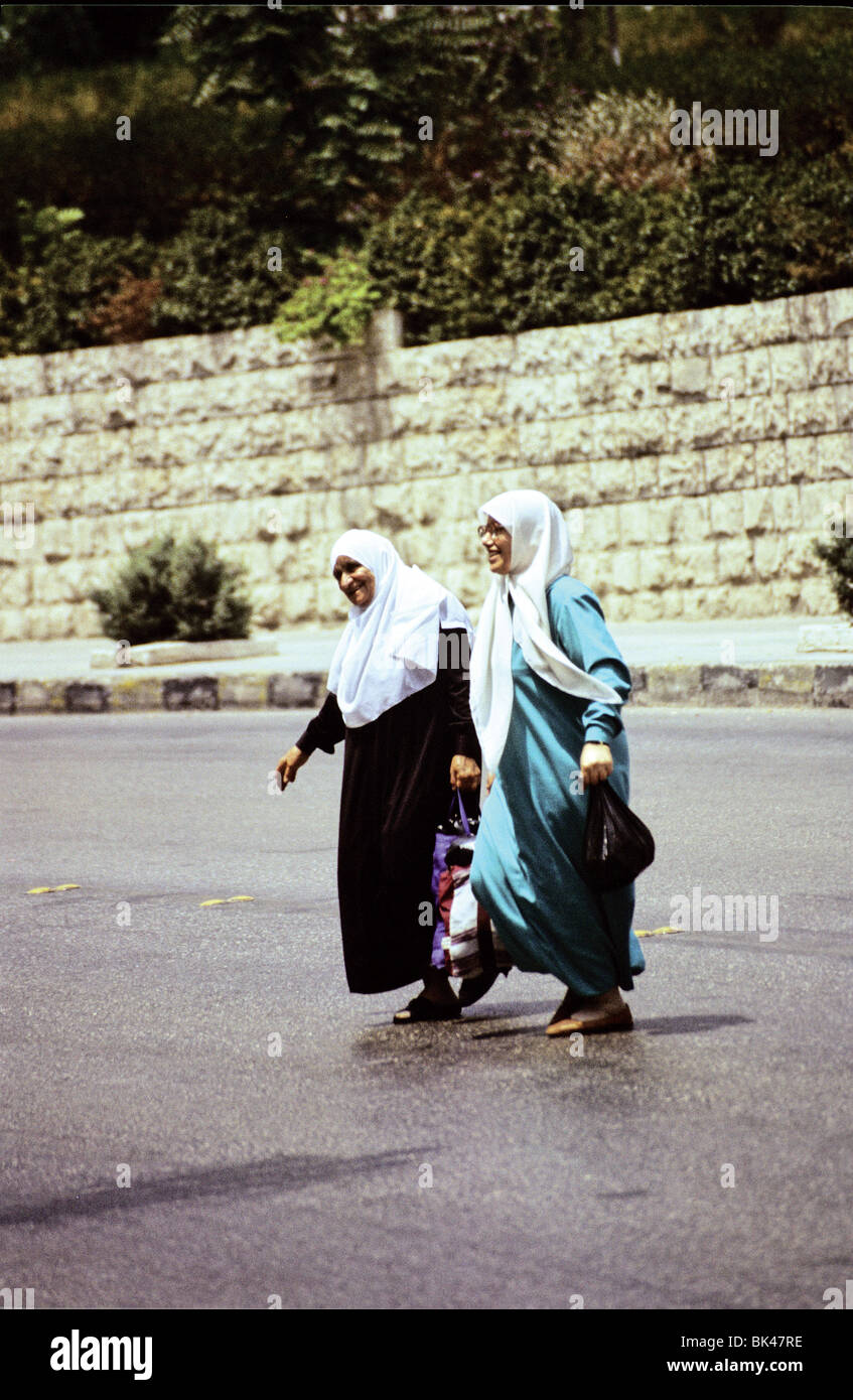Due donne che attraversano la strada di Amman in Giordania Foto Stock