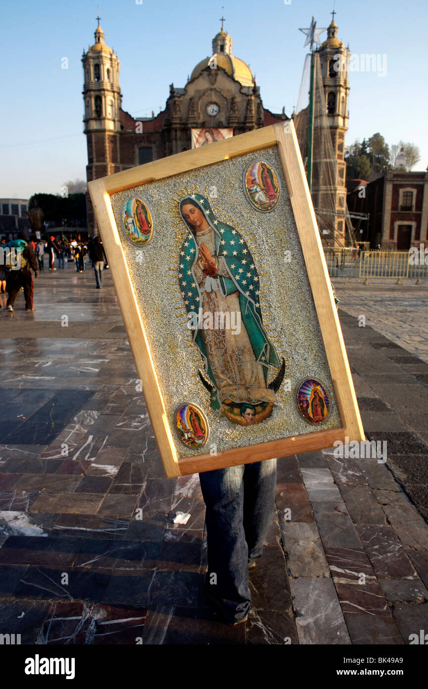 Un pellegrino trattiene una immagine della Vergine di Guadalupe sulle sue spalle nella Basilica di Guadalupe a Città del Messico Foto Stock