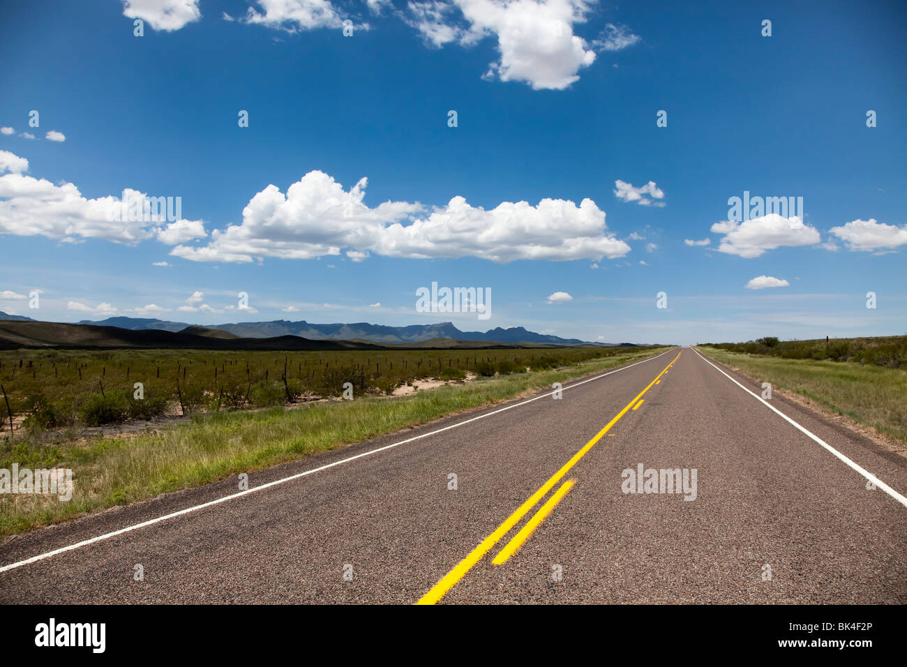 Strada vuota con Davis montagne in distanza Texas USA Foto Stock