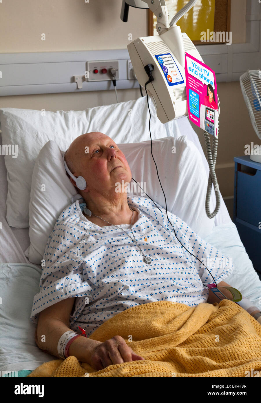 Paziente nel letto di ospedale a guardare la televisione con cuffie Wales  UK Foto stock - Alamy
