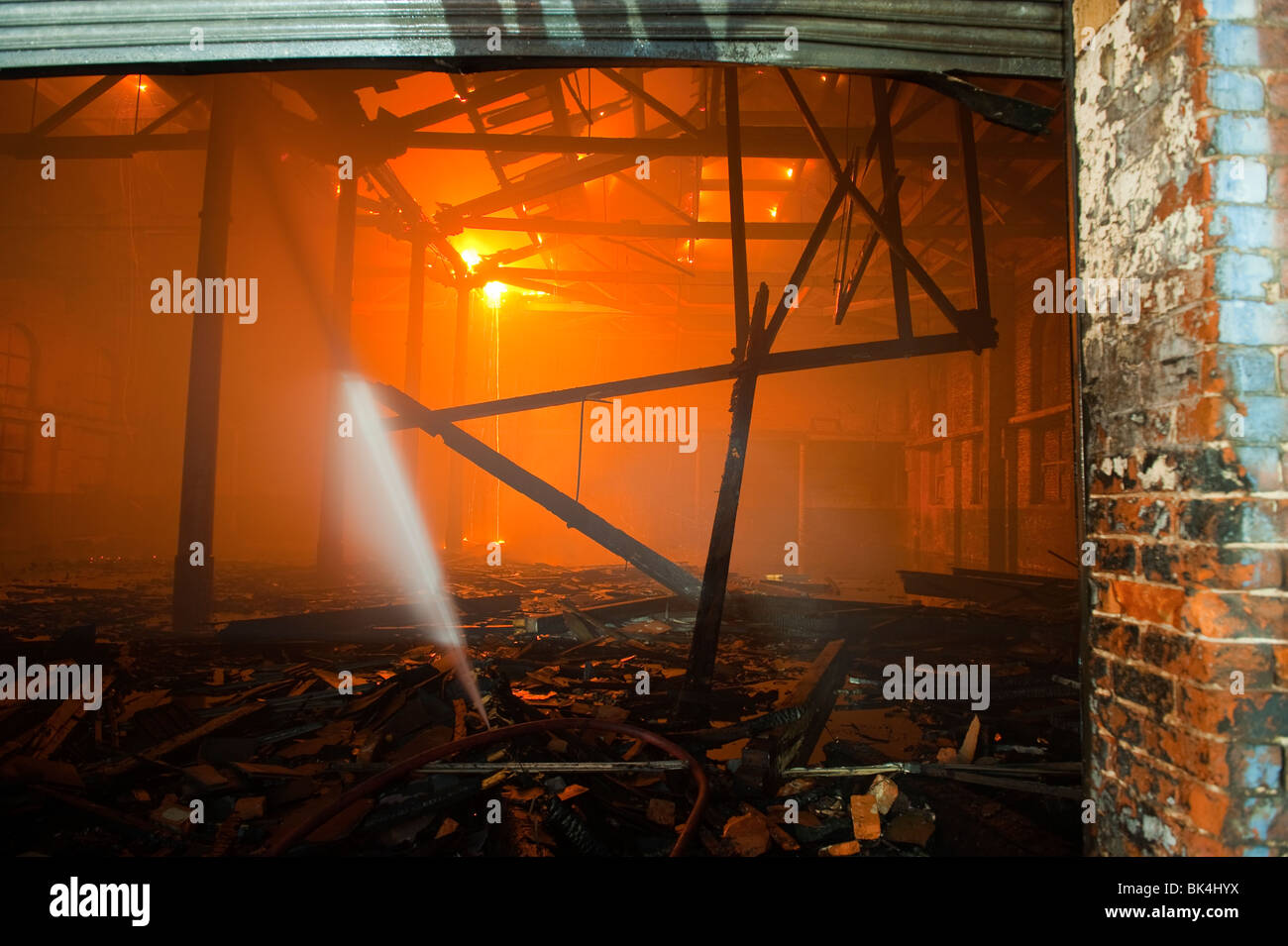 All'interno del magazzino sul fuoco con travi del tetto sta crollando e fiamme Foto Stock