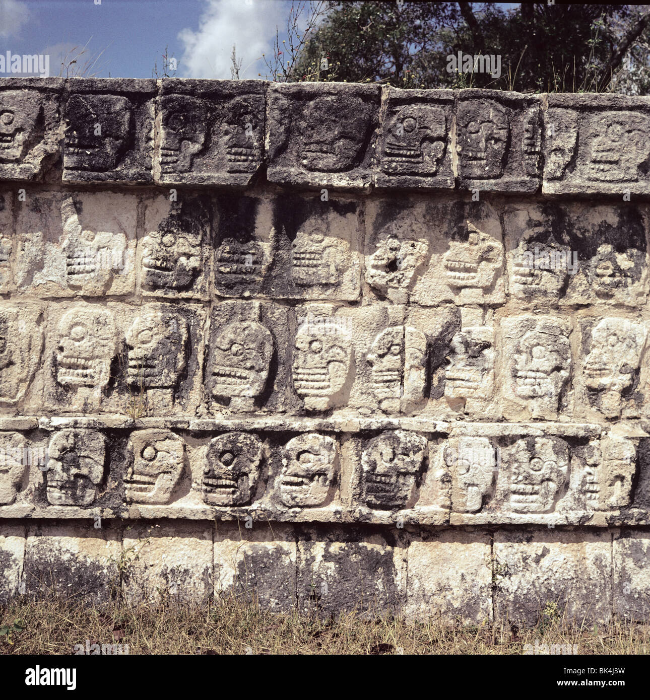 Dettaglio di El Tzompantli o piattaforma di teschi a Maya sito storico di Chichen Itza Messico - sollievo la scultura raffigura le vittime Foto Stock